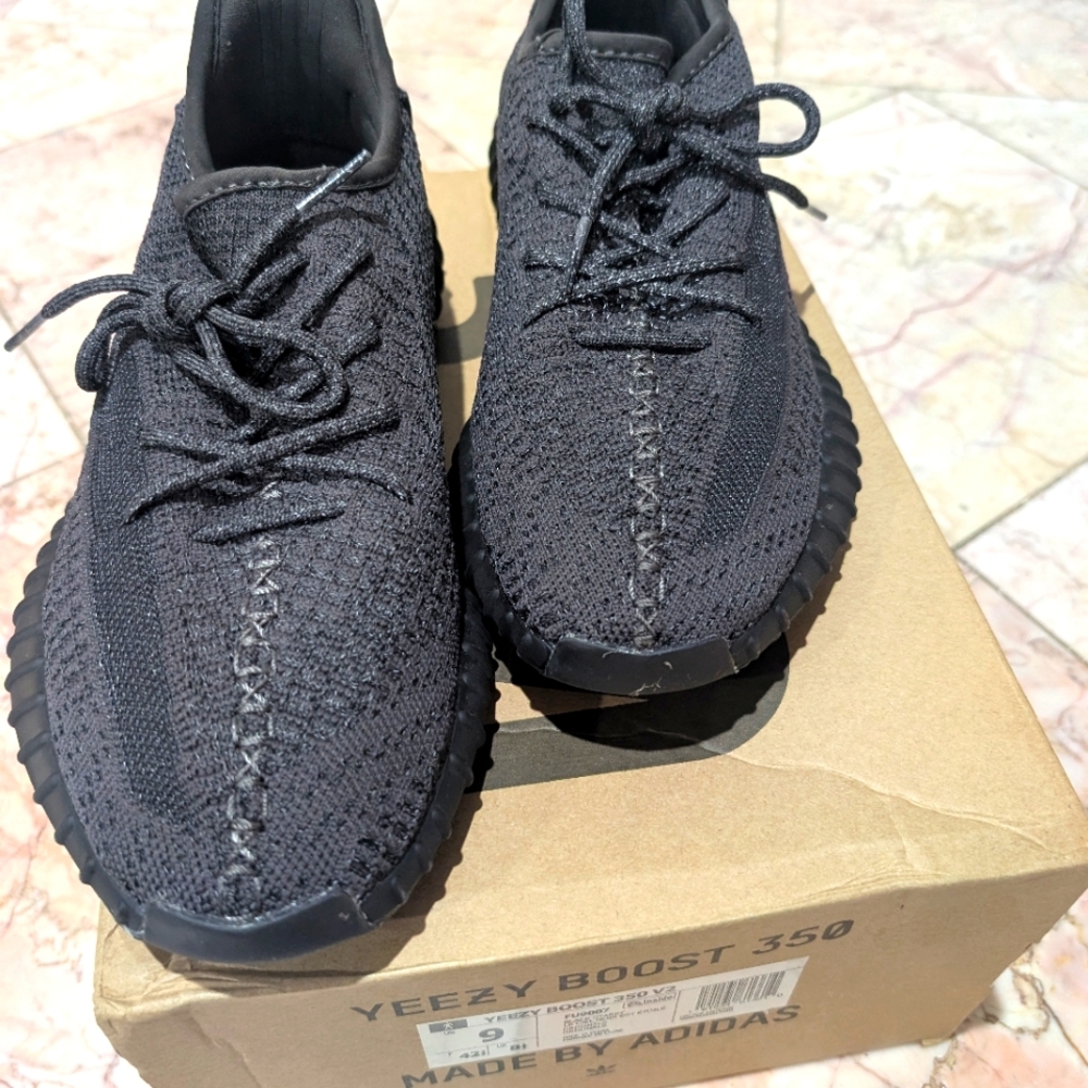 Black Adidas Yeezy Sneakers with Knit Upper and Textured Midsole.